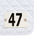 Jackie&Co Lucky Numbers pins holding competition numbers to a white saddle pad.