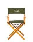 Folding production style chair with green fabric and brown wood.