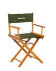 Folding production style chair with green fabric and brown wood.