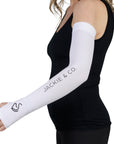 White UV protective riding sleeves featuring thumb holes, with 'Jackie&Co' written in black along the forearm and a line art horse logo on the top of the hand being worn.