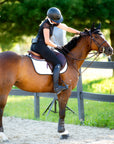 A chestnut horse wearing the perfecto saddle pad with a rider petting it's mane.