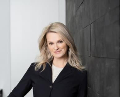 A headshot of Jackie in a suit. 