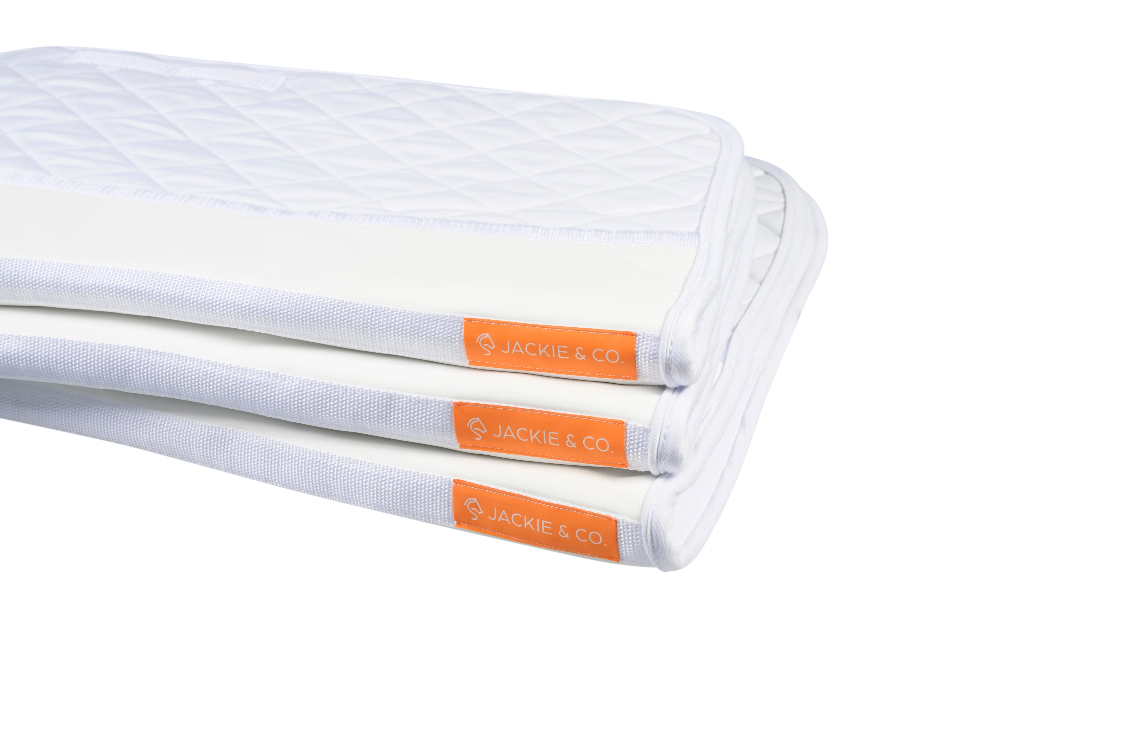 A stack of three friction shield saddle pads showing the orange Jackie&Co tag along the top seam. 
